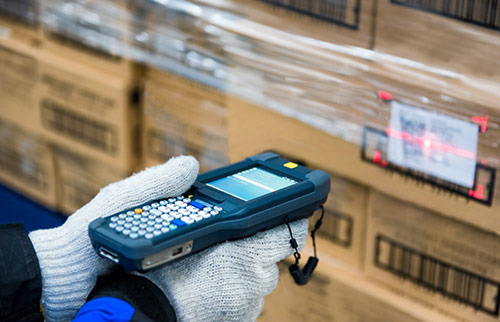 Hand scanning packages in warehouse